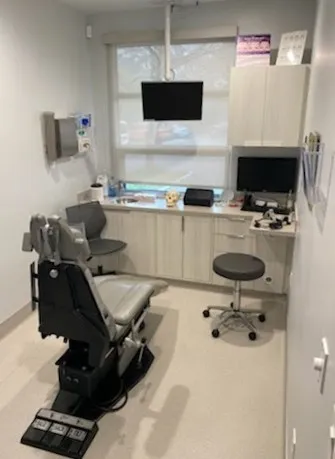 A dental office with a chair and desk.