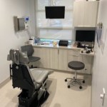 A dental office with a chair and desk.
