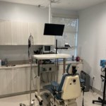 A dental op room with a chair and a television.